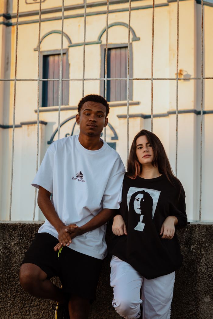 Two stylish adults posing outdoors in casual urban fashion.